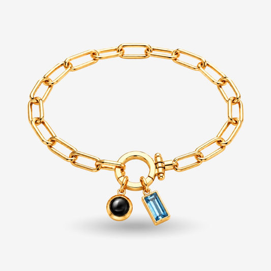 Birthstone & Projection Bracelet with gold paperclip chain, round projection charm, and blue birthstone.