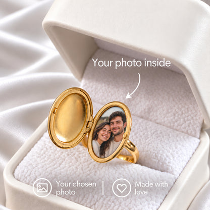 Oval Locket Ring in gold, shown open in a white ring box to reveal a couple’s photo inside the oval locket.